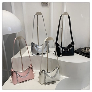 Detail view of crescent moon shoulder bags in pink silver black and cream with metal chains