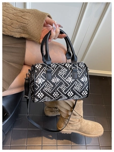 Detail view of the black and white geometric embroidery on the Boston bucket handbag