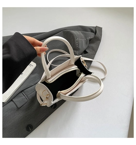 Overhead view showing interior compartments and dual zippers of the cream woven tote bag