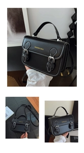 Detail of black PU leather crossbody bag with white contrast stitching and silver buckles