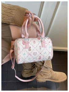 Detail of white quilted Boston bag with cute cartoon prints and pink leather handles