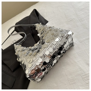 Close-up of layered silver sequins and thin leather strap on the stylish underarm bag