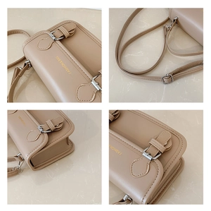 Detailed view of beige crossbody bag showing silver buckles and precise stitching texture