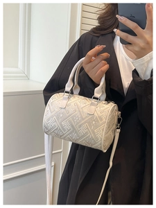 Detail of checkered barrel bag featuring jacquard texture and adjustable strap