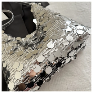 Detailed macro view showing shiny silver metallic sequins and texture of the handbag