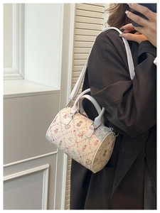 Detail of cream barrel bag featuring colorful cartoon bear prints and ruffled texture fabric
