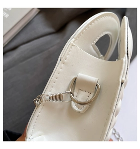 Detail of white PU leather handbag featuring D-ring hardware and neat white stitching