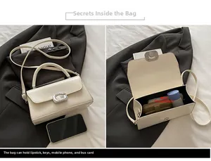 Detail of cream white bag showing main pocket capacity for phone and silver G-clasp