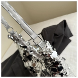 Close-up of silver sequin shoulder bag showing detailed metallic rings and stitching