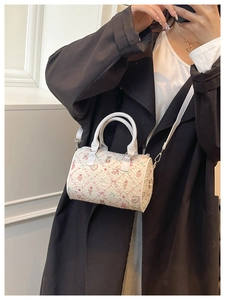 Detailed view of white bucket bag with cartoon bear print and adjustable shoulder strap