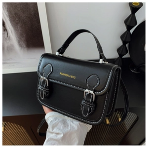 Detail of vintage black crossbody bag with white stitching and silver buckles