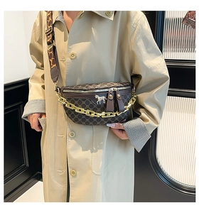 Detail of vintage saddle bag with gold metal horse logo and chunky chain strap
