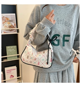 Detail of white quilted underarm bag with cute animal prints and ruched handle strap