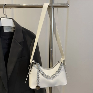 Elegant white crescent shoulder bag with silver chain detail on a minimalist hanger