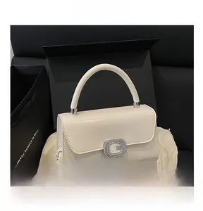 Detail of white glossy mini square bag with a sparkling rhinestone-encrusted G buckle