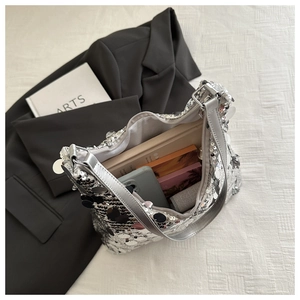 Internal view of silver sequin shoulder bag showing storage space for phone and books