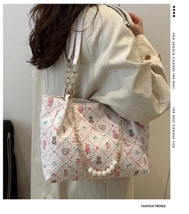 Close-up of floral tote bag with heart patterns and elegant pearl metal chain detail