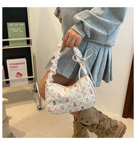 Detail of white printed hobo bag with pink bear patterns and ruffled shoulder strap