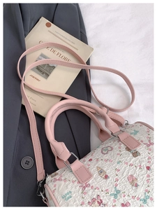 Detail of pink textured Boston bag featuring cute floral bear prints and silver D-rings