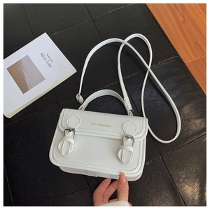 Detailed top view of white crossbody bag featuring silver buckles and gold logo text