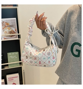 Detail of white printed hobo bag with cartoon bears and ruffled handle design