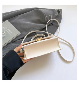 Detail of cream white leather mini bag featuring polished gold-tone turn-lock closure