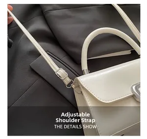 Close-up detail of adjustable leather shoulder strap and metallic buckle on white bag