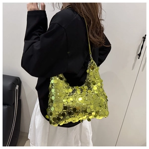 Detailed close-up of a green sequined underarm bag with sparkling metallic circular discs