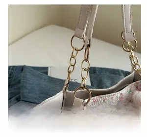 Detailed view of tote bag featuring cute cartoon animal prints and gold metal chain links