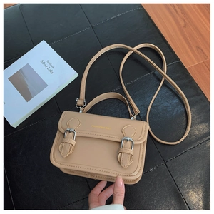 Detailed view of khaki Cambridge bag with metal buckles and FASHION & BAG lettering