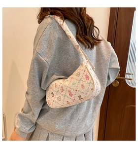 Detail view of a quilted white shoulder bag featuring cute cartoon bear and bunny prints