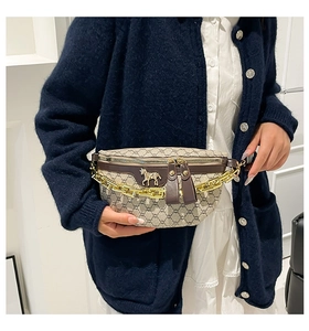 Close-up of monogram waist bag featuring gold horsebit buckle and chain on model