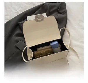 Detail view of the open cream flap bag interior showing capacity for phone and makeup
