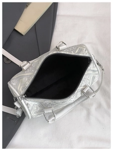 Top view of white jacquard bucket bag showing spacious black lining and silver hardware