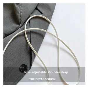 Close-up of the white leather round rope shoulder strap on a ballet-style crossbody bag