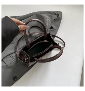 Detail view of coffee brown crocodile pattern handbag with interior zip compartment