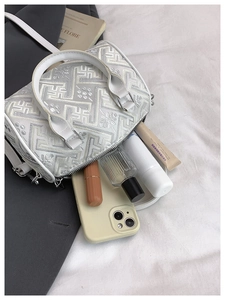 Detailed view of white embroidered bucket bag showing spacious interior and storage