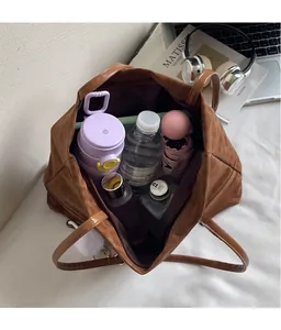 Detailed interior view of a brown tote bag showing large capacity for laptop and umbrella
