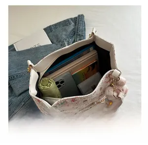 Top view of floral tote bag showing spacious interior with books and accessories