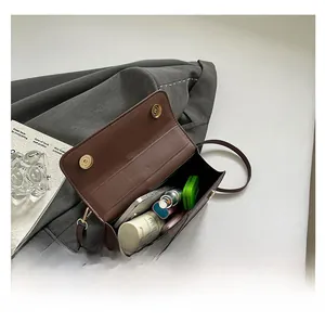 Detail view of the deep brown leather bag showing spacious interior for essentials