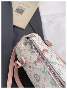 Detail of cream barrel bag featuring bubble fabric texture and cute cartoon animal prints