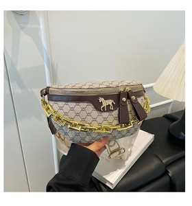 Detail of vintage monogram fanny pack with golden logo and wide textile strap