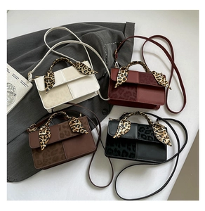 Detail of four leopard print square handbags in cream, red, brown and black colors