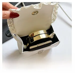 Interior view showing the large capacity of the white lace shoulder bag with cosmetics