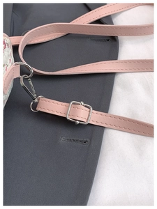 Detail of pink faux leather strap with silver lobster clasp and neat stitching on crossbody bag