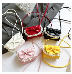Detail view of five mini bow crossbody bags with delicate lace trim in various colors