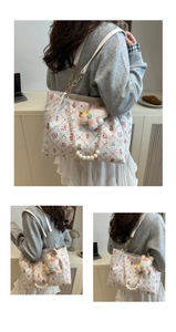 Floral tote bag detail featuring pearl chain strap and cute bear pendant on a shoulder bag