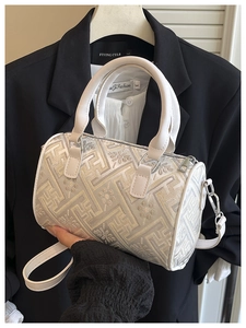 Detail of cream plaid bucket bag showing jacquard texture and white leather handle