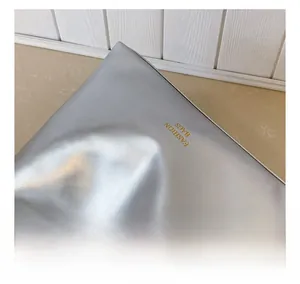 Gros plan sur la texture du cuir argenté et le logo Fashion Bags gravé sur le sac
