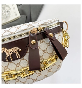 Detail of white lychee leather texture with monkey pattern and gold horse bit buckle